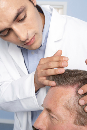 ^BMODEL RELEASED^b. ^BHair transplant consultation.^b Trichologist examining the scalp of a man who is contemplating hair transplant surgery. The doctor is checking for areas of male pattern baldness (alopecia).